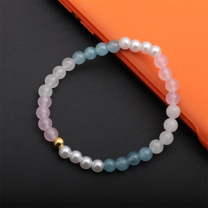 Bracelet en perles de 6MM avec cristal rose, croix et cœur sur un fond contrasté moderne