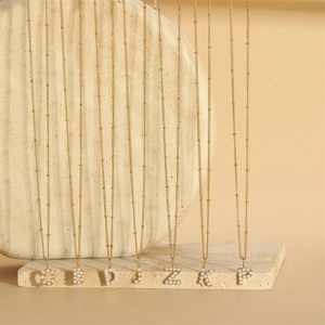 Golden fine chain necklace featuring personalized pearl-inlaid letters pendants