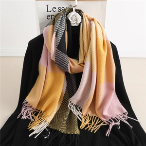 Detail of color-block plaid scarf showing soft texture and twisted fringe tassels