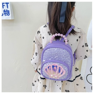 Detail of purple sequin kids backpack with shell pocket and pearl handle shown on model