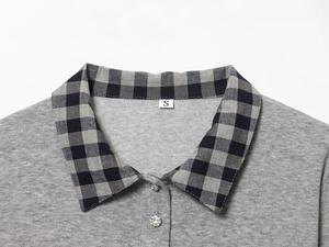 Close-up of polo neck with rhinestone buttons and grey plaid collar on a knit top