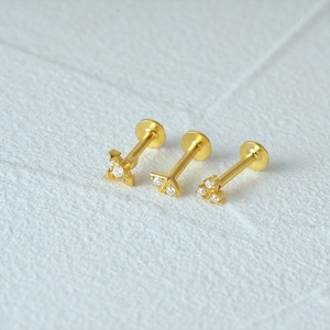 Detail of 925 silver gold-plated threaded earrings with diamond cross and cluster designs