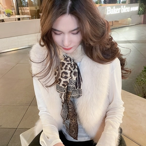 Close-up of white faux fur vest with luxury leopard print ribbon scarf and chain patterns