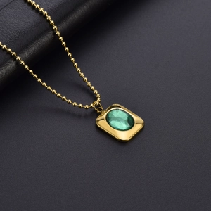 Luxurious gold ball chain necklace with emerald green rectangular gemstone pendant