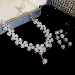 Exquisite pearl necklace and earrings set with sparkling rhinestones in a gray jewelry box