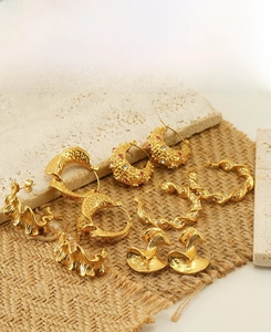 Detailed macro view of 18K gold plated stainless steel textured earrings and zircon hoops