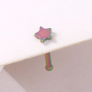 Macro shot of colorful star-shaped stainless steel nose stud with iridescent metal finish