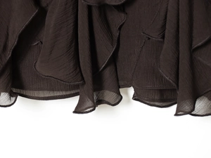 Détail du tissu en mousseline marron café avec des volants élégants et une texture plissée