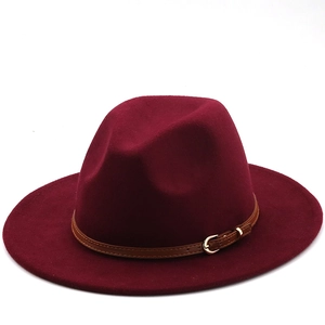 Detail of burgundy wool fedora hat featuring a brown leather band and gold buckle