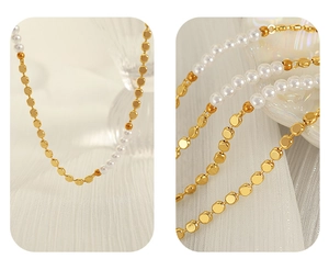 Detail of a gold beaded chain necklace with fresh water pearls on a textured fabric