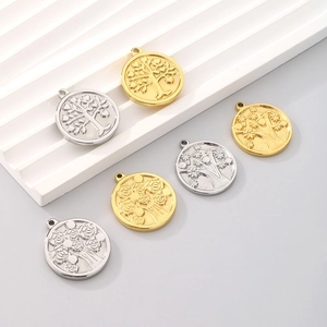 Detailed view of Tree of Life round pendants in gold and silver stainless steel finish