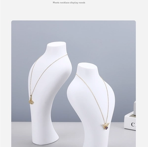 Detailed view of two white matte resin mannequin stands for necklace and jewelry display
