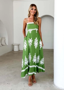 Detailed embroidery on green backless maxi dress with a minimalist arch background