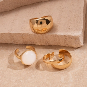5-piece gold geometric resin ring set on natural stone, featuring minimalist metal designs