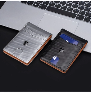 Close-up of slim carbon fiber RFID wallets in silver and black on a laptop keyboard