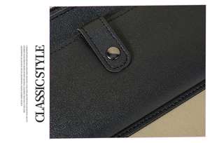 Close-up of black lychee grain leather wallet with a round metal snap button closure