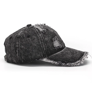 Detail of distressed denim baseball cap with vintage frayed edges and ripped holes
