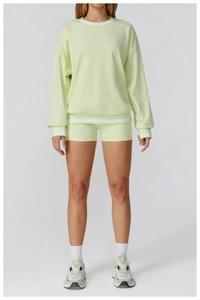 Detail view of light green sweatshirt with white striped hem and matching shorts
