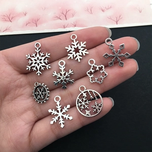 Verschiedene Vintage-Silber-Schneeflocken-Anhänger für DIY-Schmuck in der Hand
