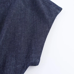Gros plan détaillé sur la texture et les coutures du tissu denim bleu foncé de la robe