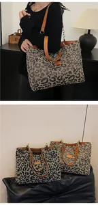 Detail of leopard print tote bags with dual handles and metal chain decoration