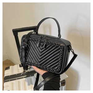 Dettaglio della borsa in pelle trapuntata con catene metalliche e tracolla regolabile