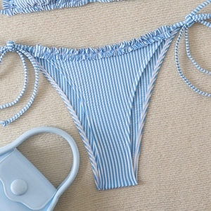 Close-up of blue seersucker bikini bottoms with ruffle trim and side tie detailing