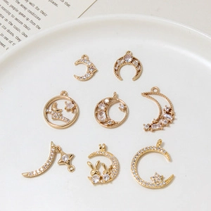 Detailed close-up of gold-plated moon and star charms with sparkling cubic zirconia