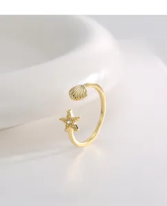 Detail eines verstellbaren Goldrings mit Seestern-Zirkon und Muschelmotiven