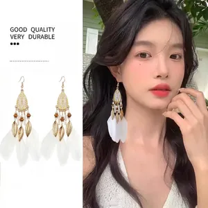 Bohemian white feather earrings with gold leaf accents and colorful beads in a pair