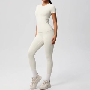 Two-piece ivory yoga set featuring a short sleeve crop top and high waist leggings