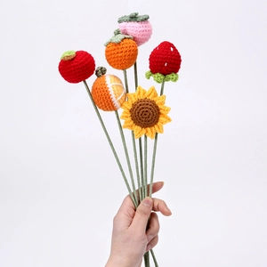 Handmade knitted bouquet with strawberry, sunflower and fruits on a white background