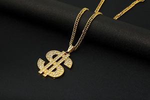 Close-up of hip-hop gold dollar sign pendant necklace with micro-pave white crystals