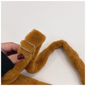 Detail of plush brown shoulder strap with adjustable metal buckle on a Capybara bag