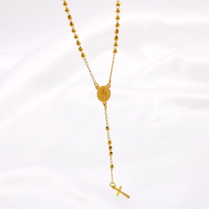 Minimalist gold rosary necklace with cross pendant on white satin background