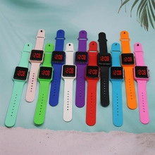 Flat lay of colorful silicone digital watches with square LED screens in twelve various shades