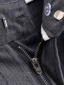 Vue macro de la fermeture éclair et du crochet sur la taille du pantalon gris