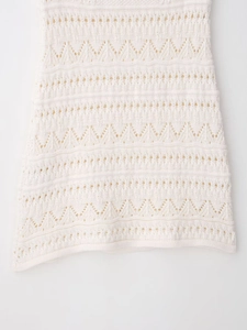 Detailed macro view of white crochet mini dress featuring intricate hollow wave patterns