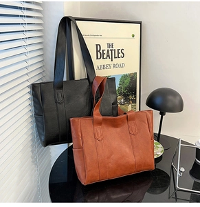Classic PU leather tote bags in black and brown colors shown in a modern lifestyle setting