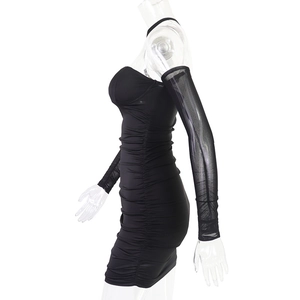 Détail d'une mini robe moulante noire froncée avec coutures en mesh et manches longues