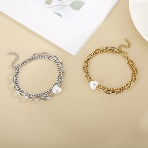 Double-layer stainless steel heart and pearl bracelet in gold on beige background