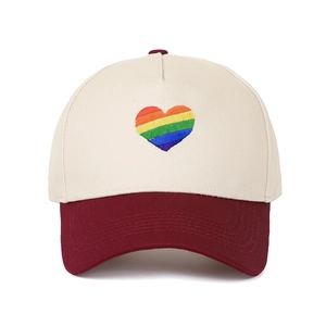 Primo piano di un cappellino da baseball bicolore con ricamo a cuore arcobaleno