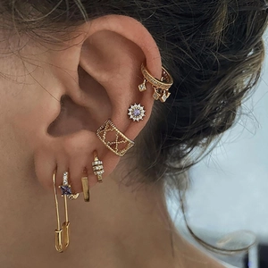 Detail of gold ear cuff set with purple zircon stones and paperclip drop earring