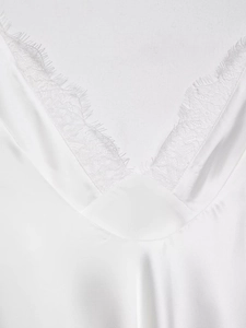 Gros plan d'un haut élégant en satin blanc avec dentelle délicate au col en V et texture