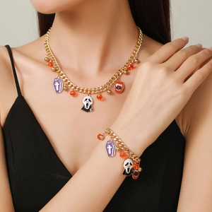 Detail of Halloween jewelry set featuring RIP coffin, mask pendants on gold Cuban chain