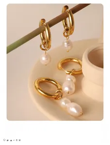 Detailed close-up of 18k gold-plated titanium earrings with elegant white freshwater pearls
