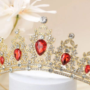 Detail of luxury gold crown with red teardrop gemstones and sparkling white crystals