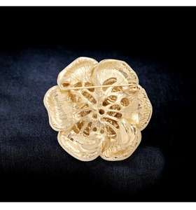 Détail de la structure arrière d'une broche fleur dorée avec fermoir épingle de sûreté