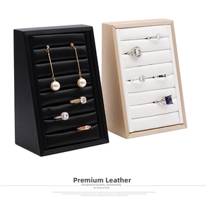 Detailed view of black and beige faux leather jewelry display stands with multiple slots