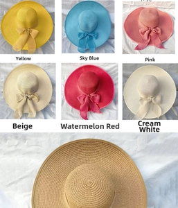 Dettaglio di cappelli di paglia a tesa larga con elegante fiocco in vari colori